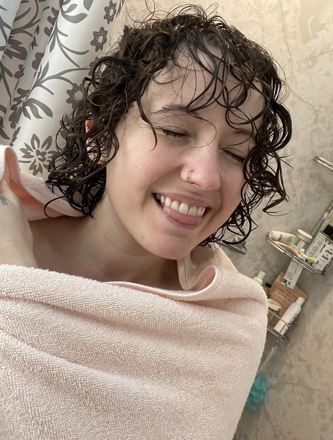 A person smiling in a pink towel
