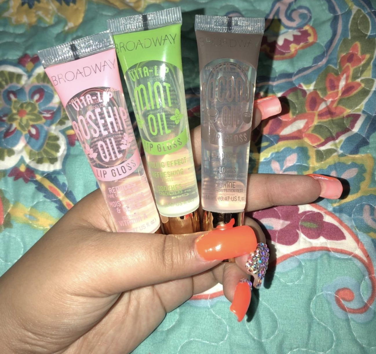 a reviewer holding the three tubes of lip gloss