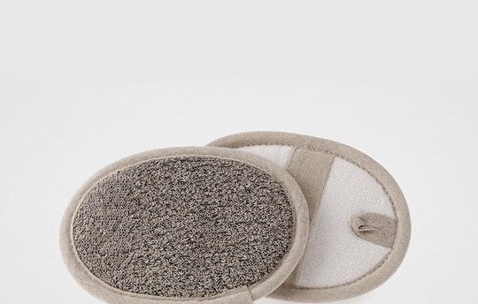 Oval skin cleaning mitt with scrubbing side and strap for hand, including a loop for hanging storage 