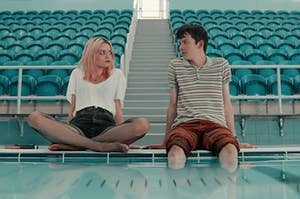 Maeve and Otis from sex education sitting with their legs hanging in a pool 