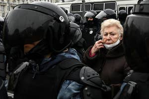 An elderly woman surrounded by police officers at a pro-Democracy rally in Russia. 