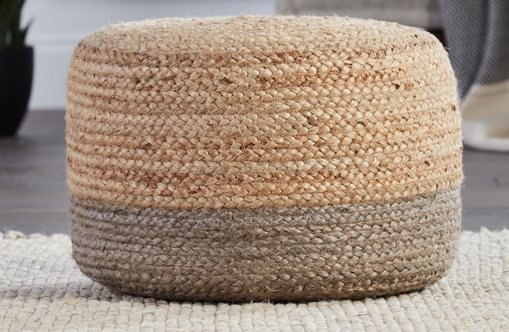 A jute pouf sitting on a rug. 