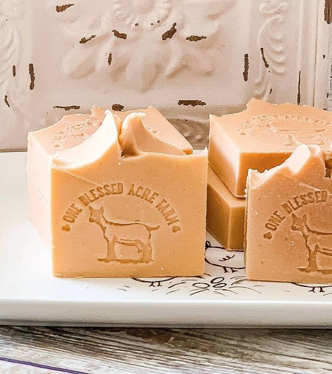 Several hand pressed bar soaps with store's logo 