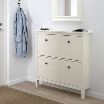 The white shoe cabinet which has four compartments