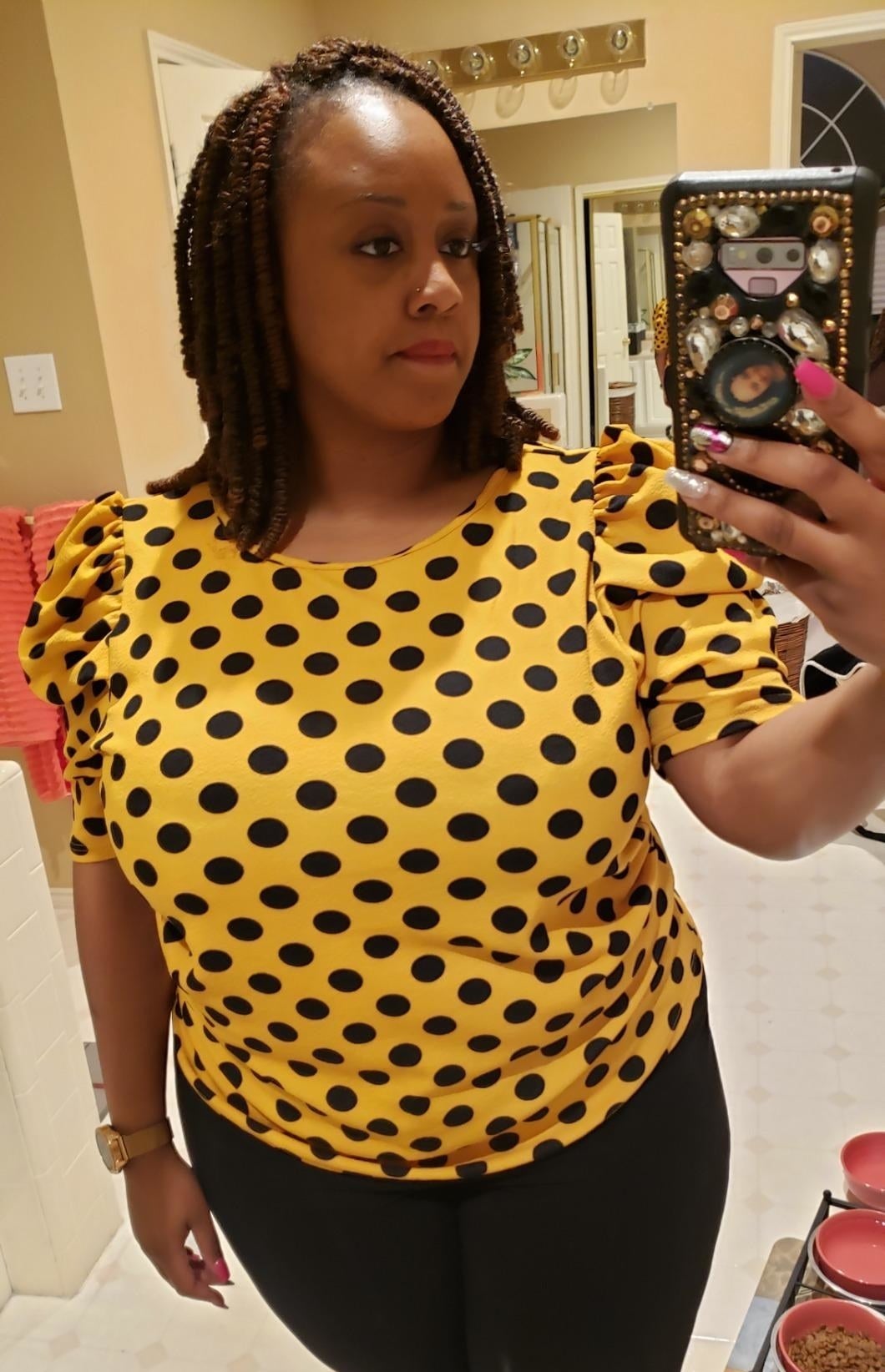A reviewer in the yellow and black dotted short sleeve top
