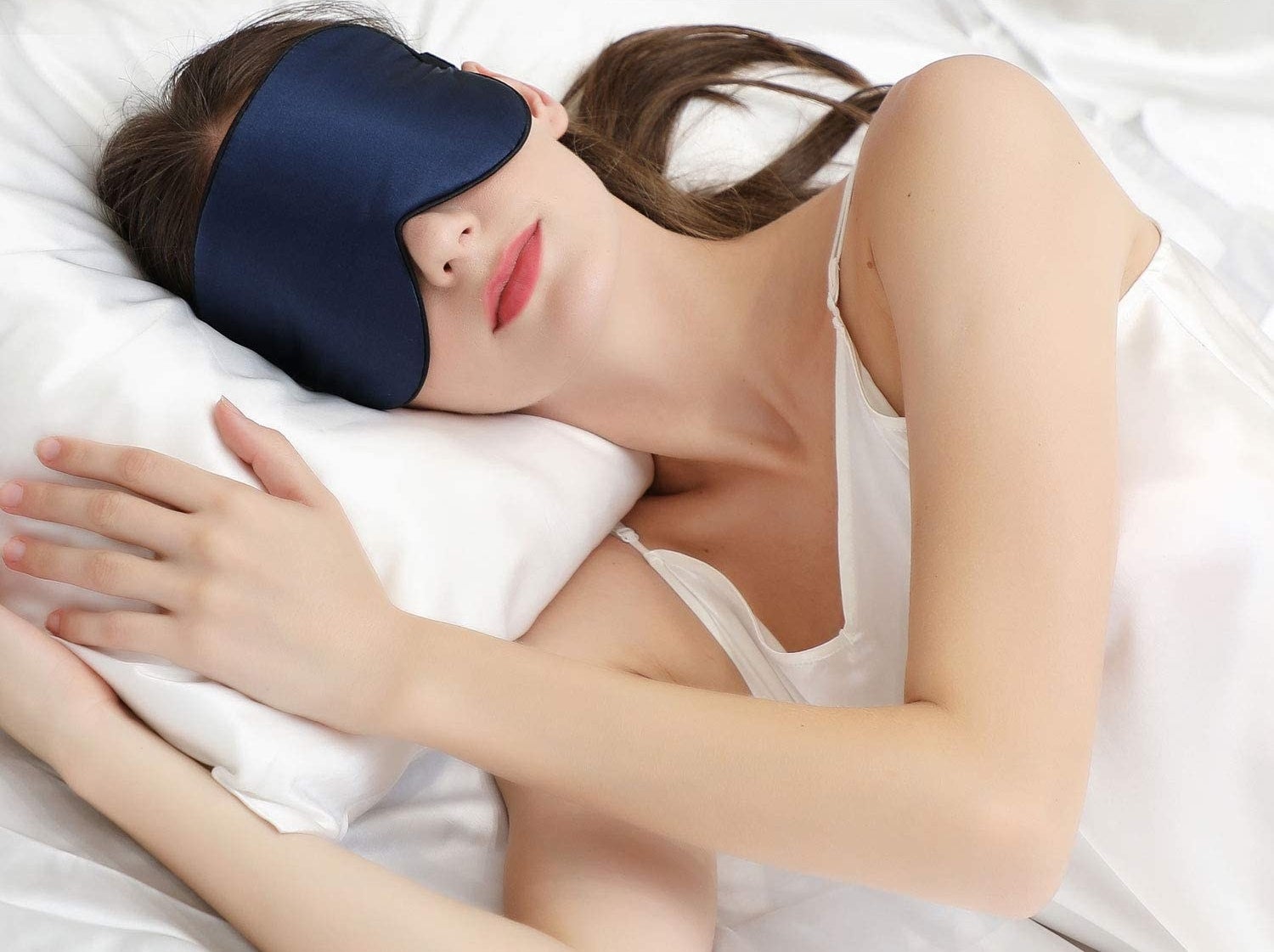 person lying down on bed with eye mask on