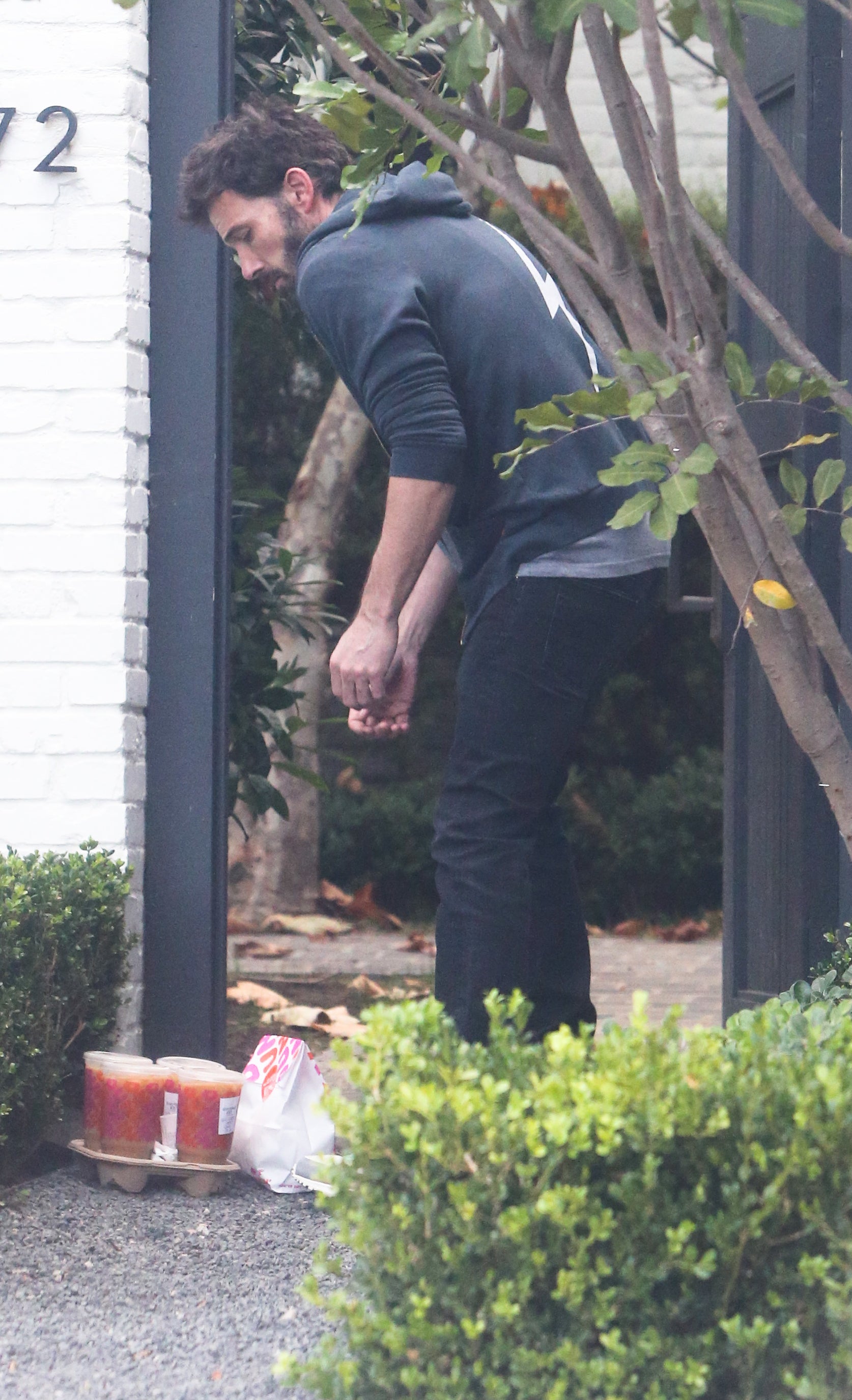 Ben retrieves four large iced coffees and a bag of food from Dunkin' that was delivered to his home