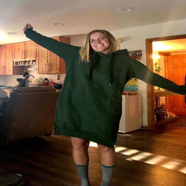 Reviewer wears same hoodie dress in a dark green shade