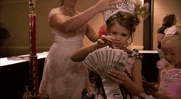 Little girl counting her prize money after winning a pageant