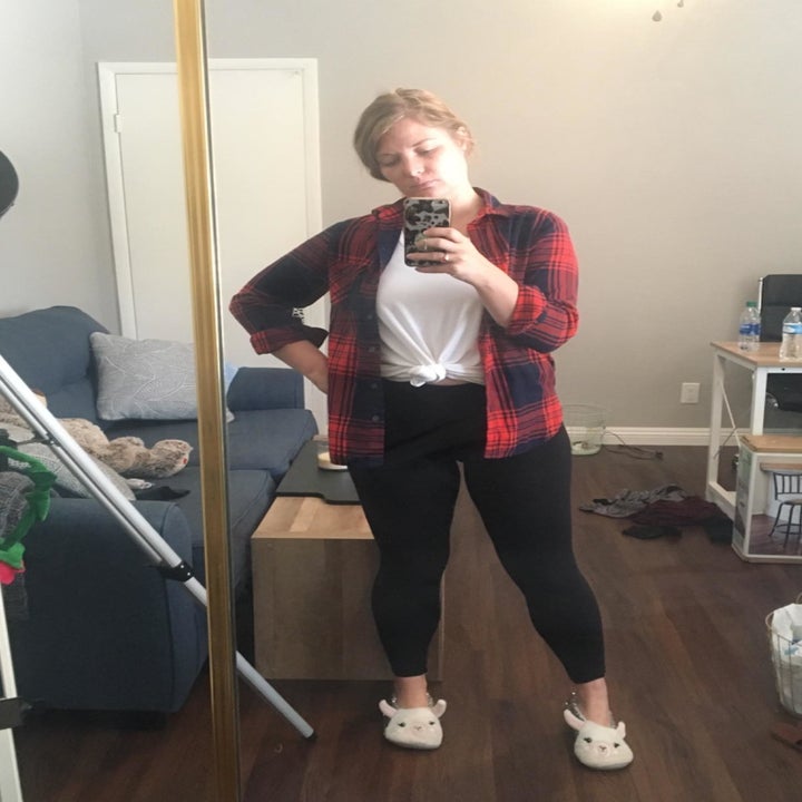 Reviewer wearing black opaque leggings with a flannel, white T-shirt, and bunny slippers