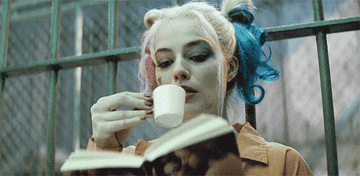 Harley Quinn reading and drinking tea in jail 