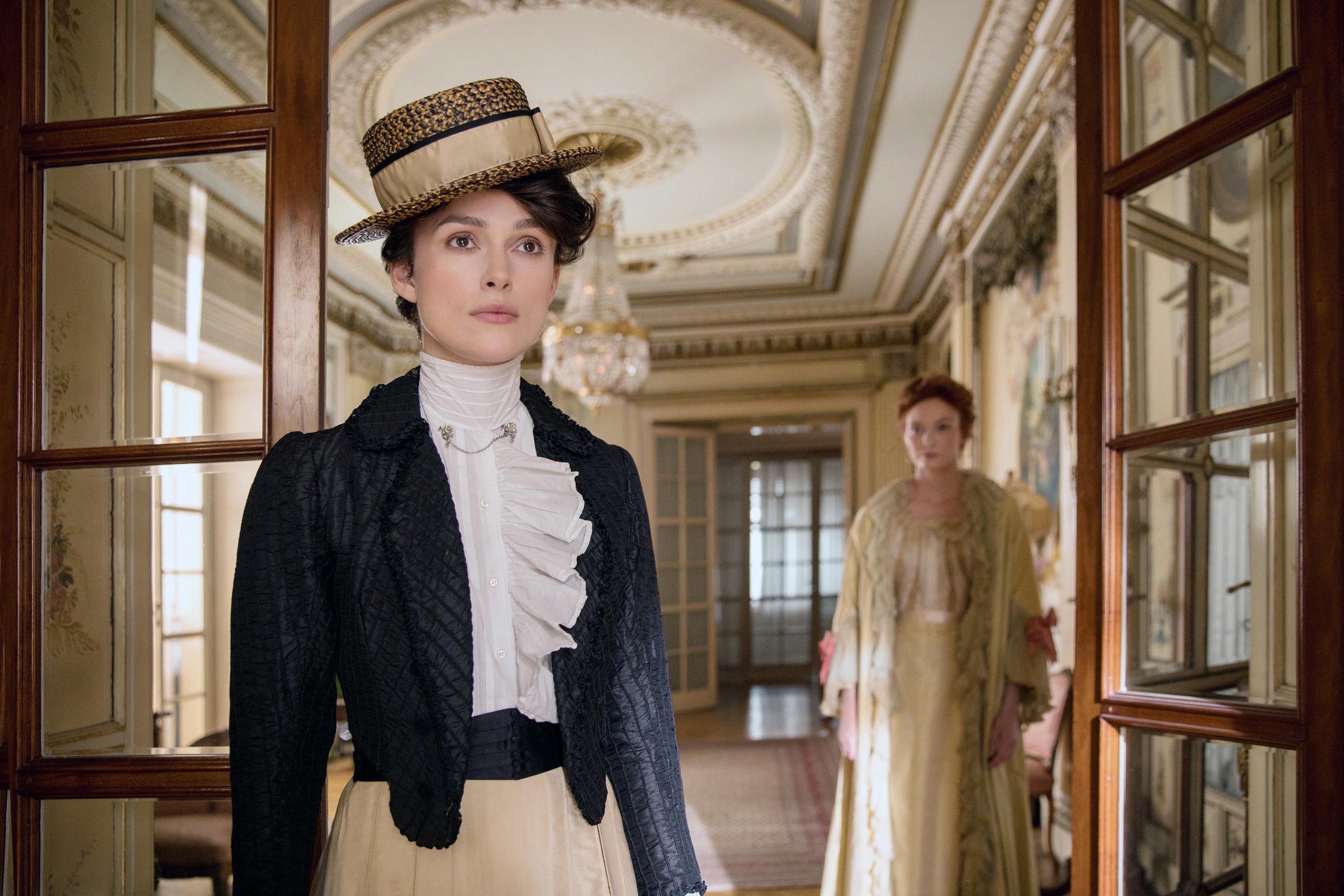 Keira Knightley stands in the foreground with Eleanor Tomlinson in the background in the 2018 film Colette