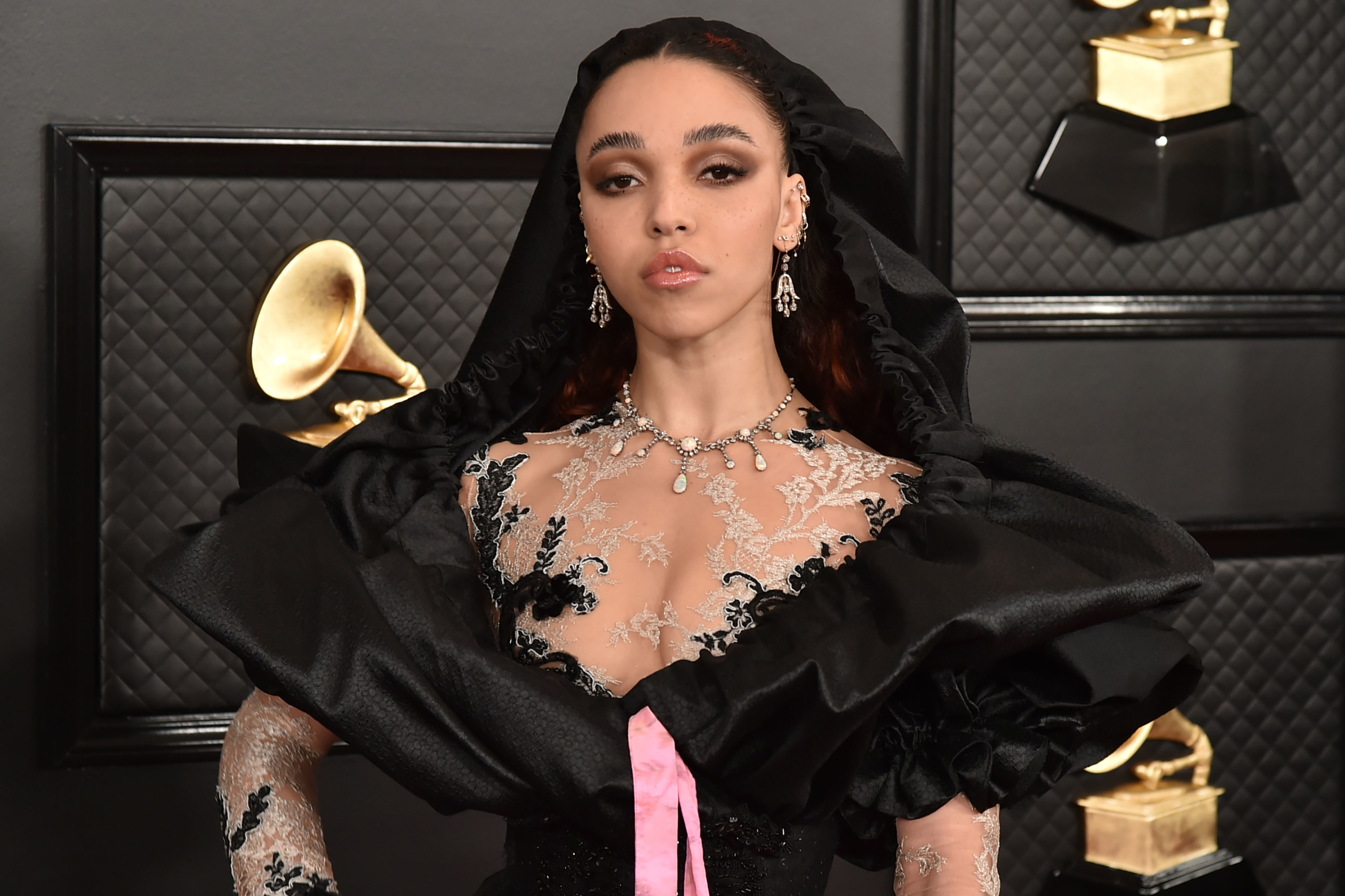 FKA twigs attends the 62nd Annual Grammy Awards in a low-cut outfit featuring lace around the neckline and a hood