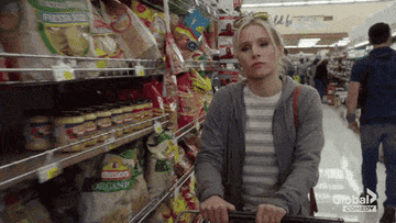 Eleanor dragging her hand along the chips shelf and throwing it all in her cart on The Good Place