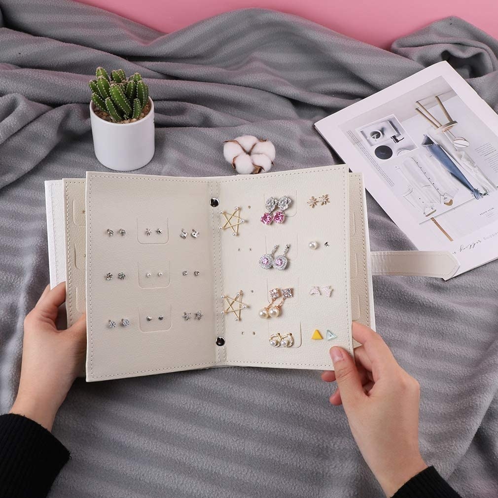 A person flipping the pages in an earring booklet