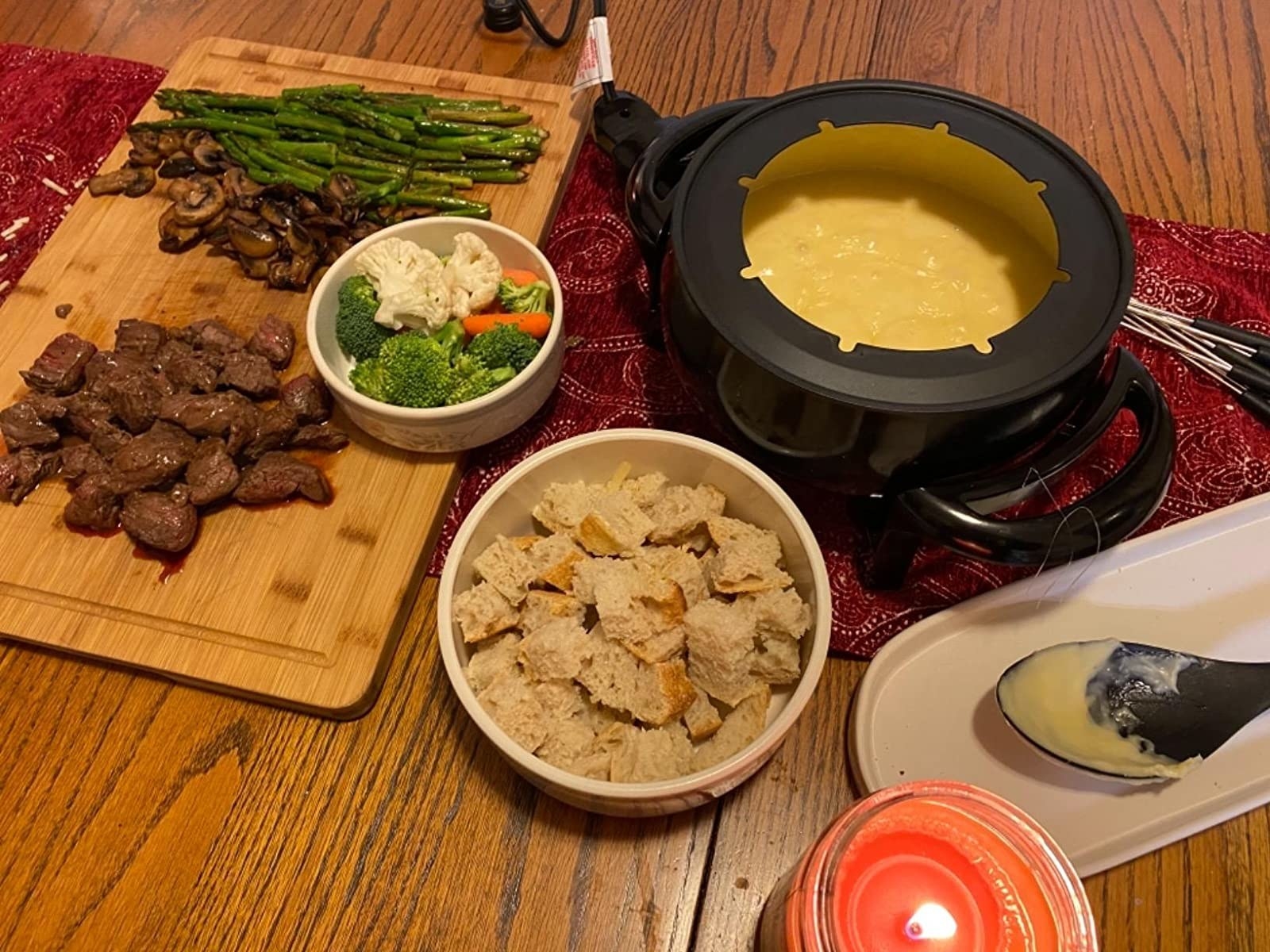 Reviewer photo of fondue poe with melted cheese and various meats, veggies, and bread