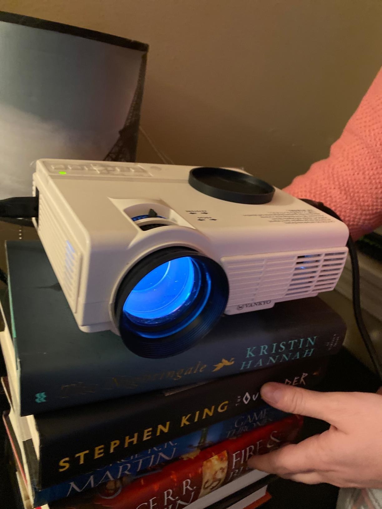 Reviewer photo of projector placed on stack of books