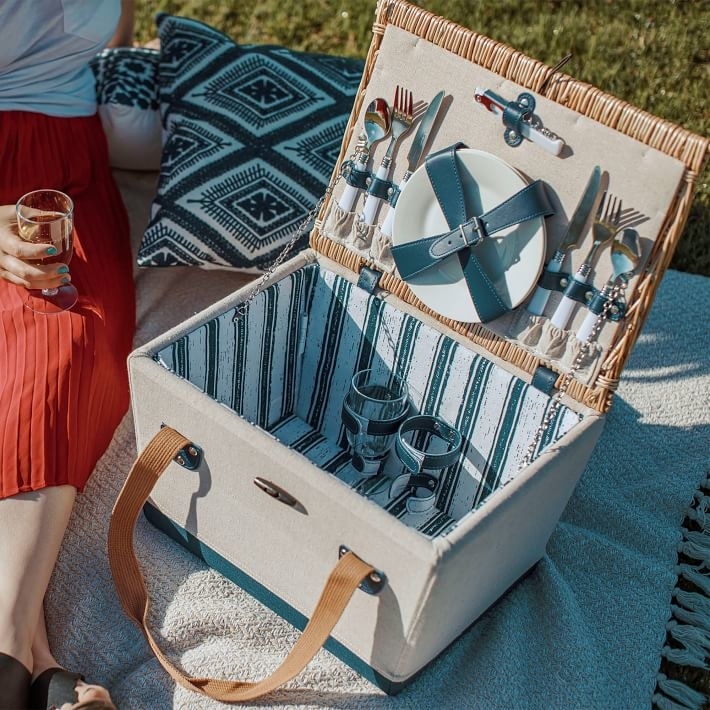 Picnic set opened to reveal plates, wine glasses and utensils