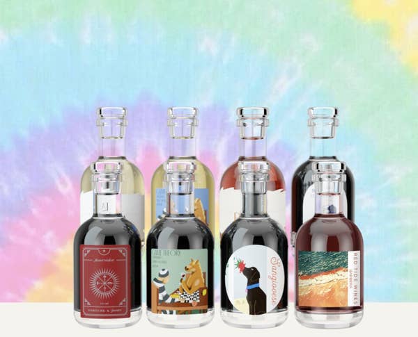 Product shot of eight mini bottles of wine on tie-dye background