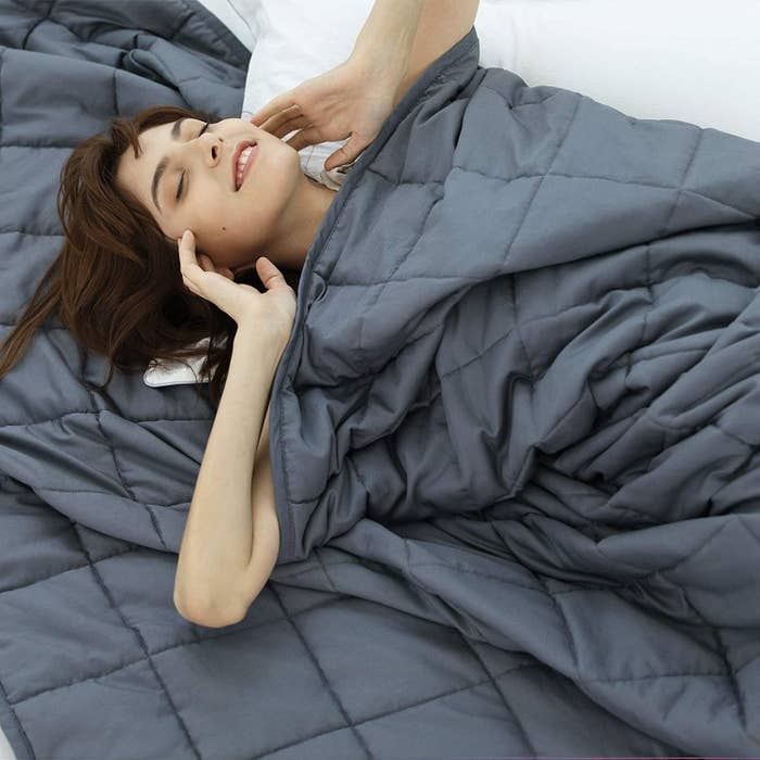 A person swaddled under a weighted blanket