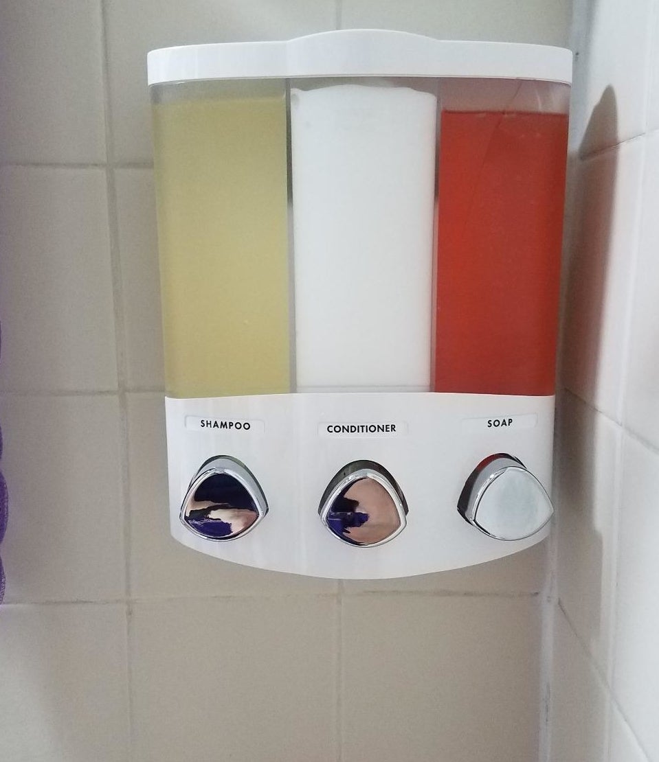 A reviewer&#x27;s soap dispenser with labels for shampoo, conditioner, and soap