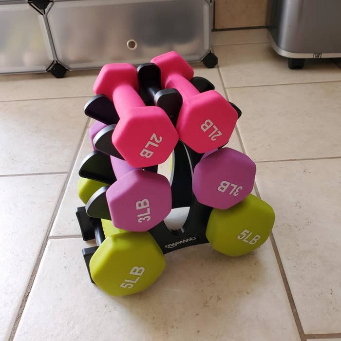 a set of two, three, and five-pound weights sitting on a black stand