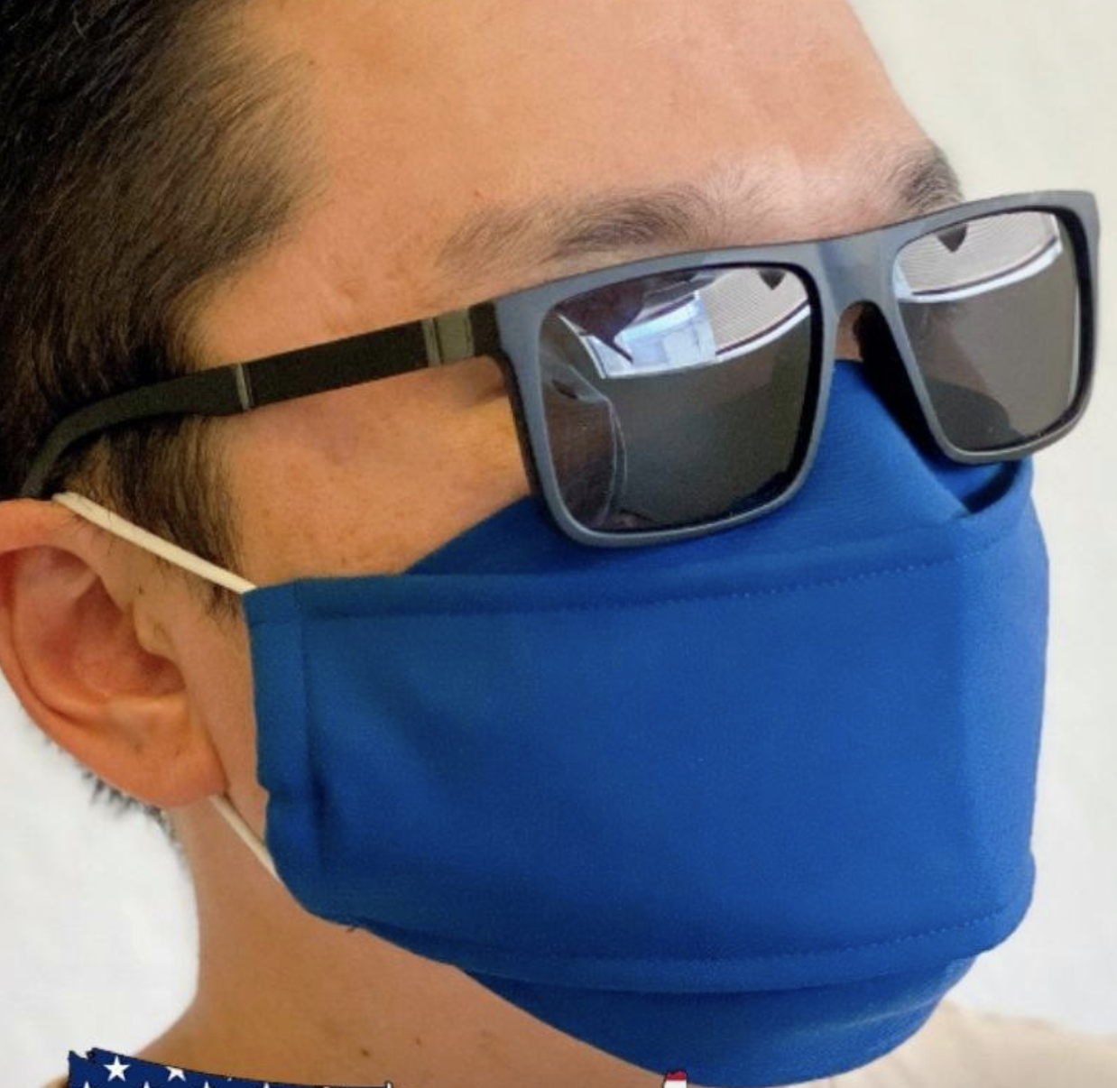 A model in a blue 3D face mask that sits more off the nose wearing a pair of sunglasses 