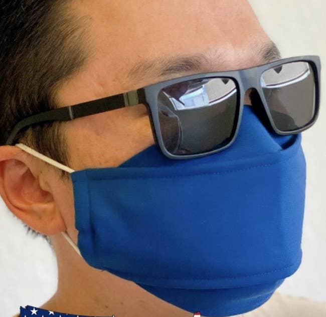 A model in a blue 3D face mask that sits more off the nose wearing a pair of sunglasses 