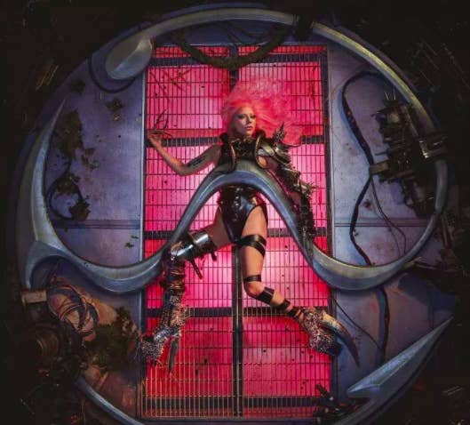 Promotion photo of Lady Gaga lying on her back with long nails and incredibly tall shoes