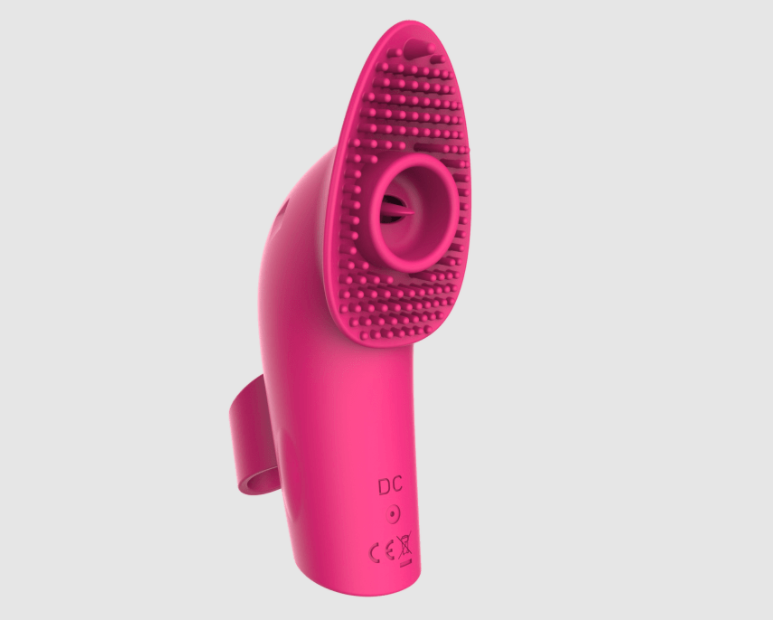 The pink toy with a finger loop, textured head, and small &quot;tongue&quot; in the middle