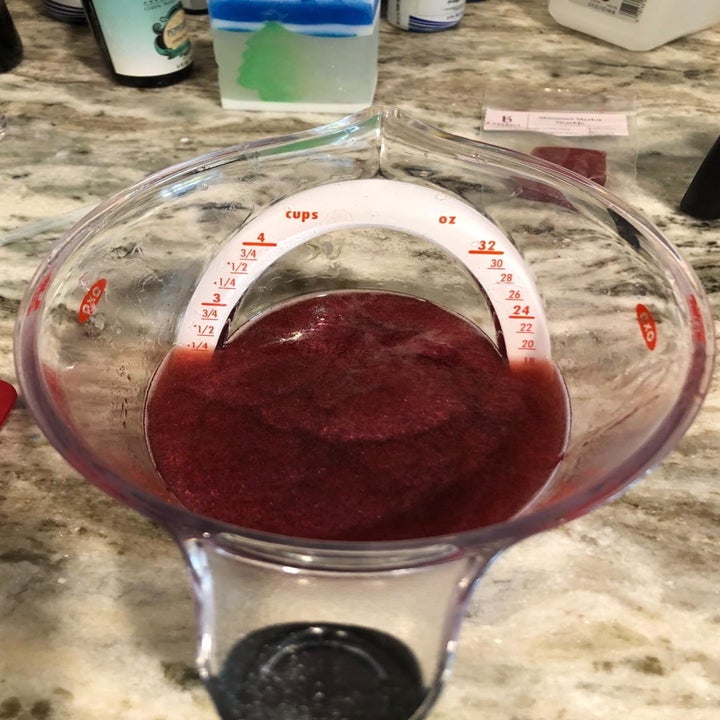 A reviewer photo showing the top-down view of a measuring cup filled with a dark purple liquid