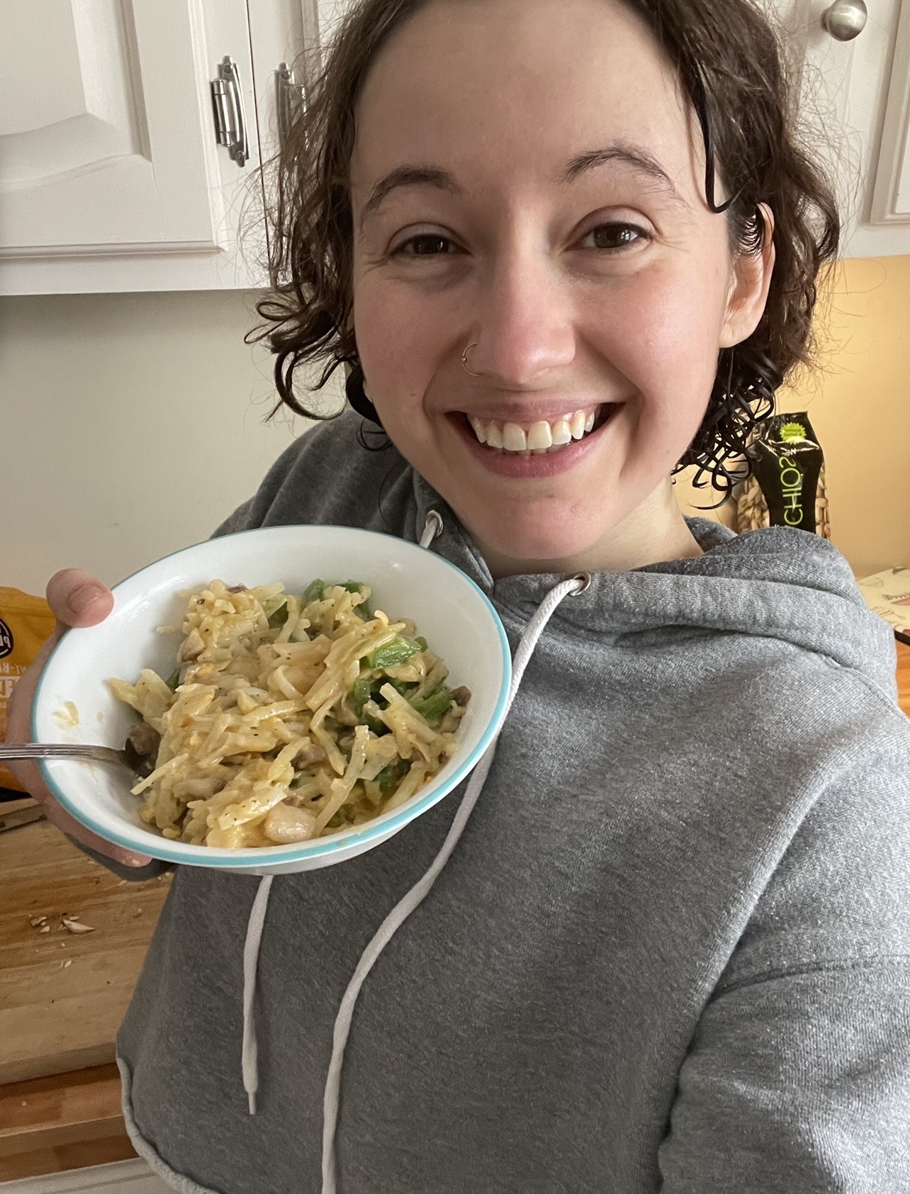 Person holding a bowl of hashbrowns