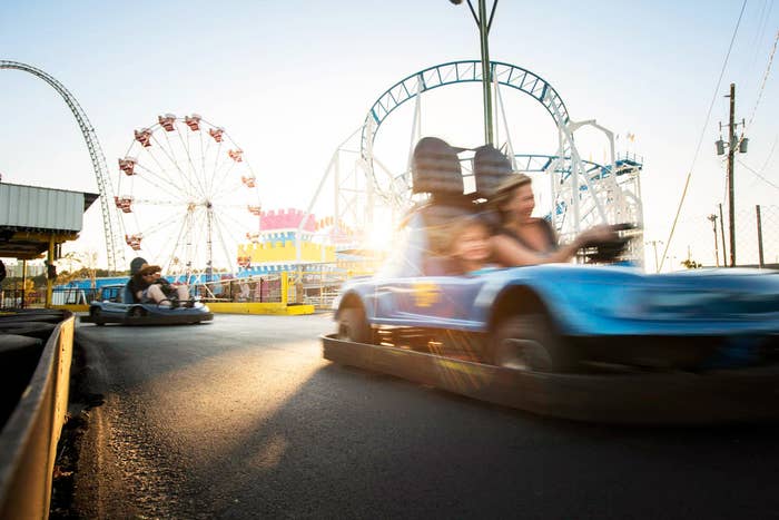 A mother and son driving a go-kart at an amusement park