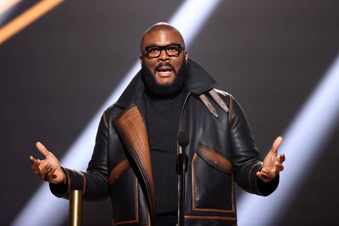 Tyler Perry accepts People&#x27;s Champion Award onstage for the 2020 E! People&#x27;s Choice Awards wearing a leather jacket and a turtleneck