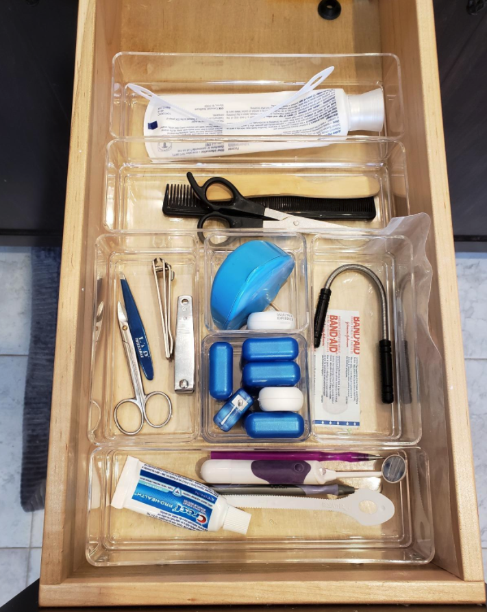 reviewer image of plastic bins holding toothpaste, nail clippers, floss and more