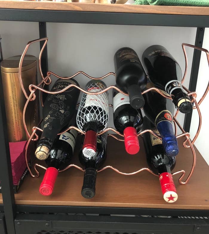 reviewer image of wine bottles stacked in a copper sorbus three tier wine rack