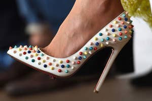A white heel with colorful studded spikes all over it