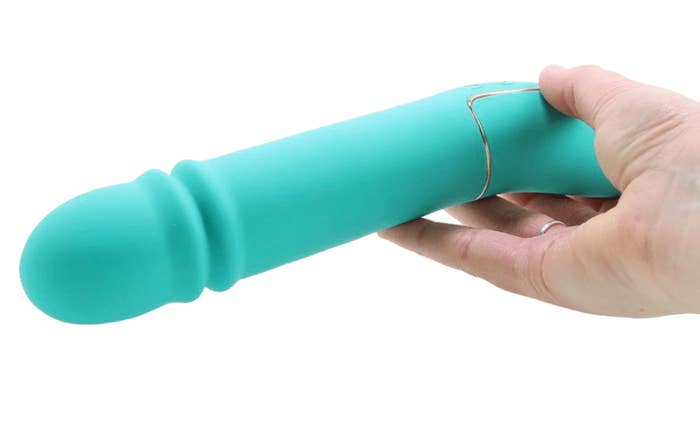 Hand holding long the teal toy