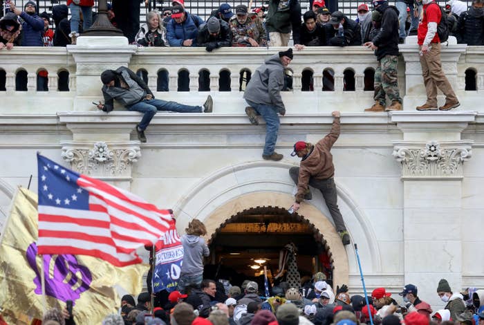 A mob of Trump supporters fight with members of law enforcement and scale walls of the Capitol