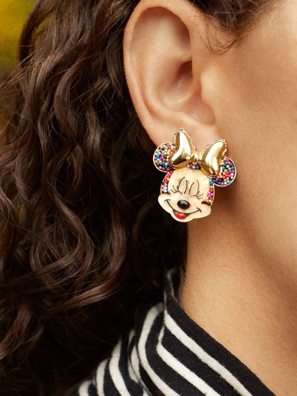 a model wearing minnie mouse earrings that look like they are filled with sprinkles