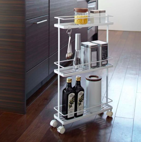 A slim rolling rack laden with kitchen accessories and utensils