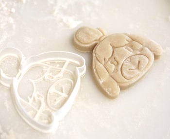 an isabelle cookie cutter next to an isabelle sugar cookie