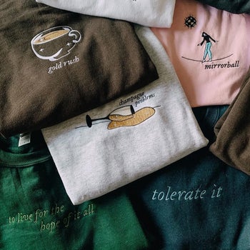 a pile of embroidered taylor swift sweatshirts