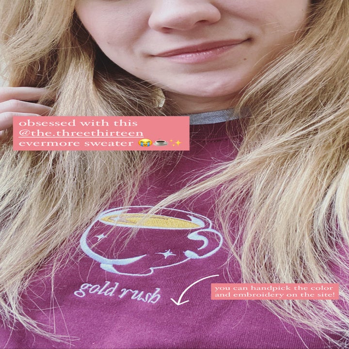 buzzfeed editor wearing an embroidered sweatshirt with a tea cup and the words "gold rush" on it