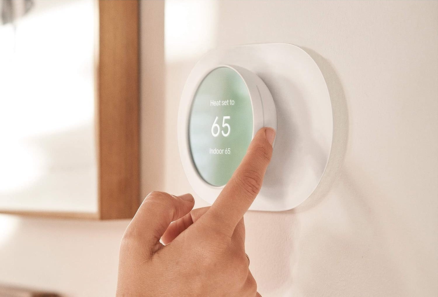 Model adjusting temperature on Google Nest thermometer