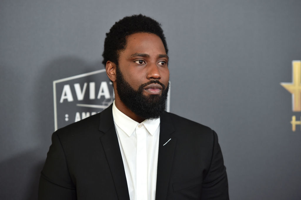 John David Washington wearing a suit and looking off-camera