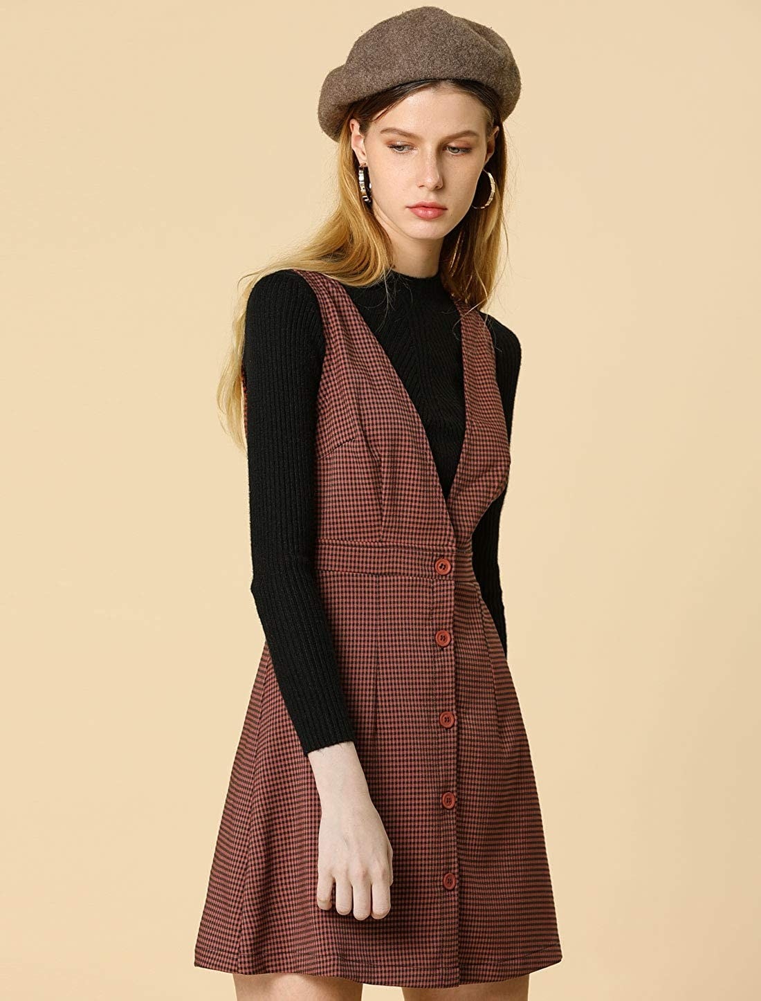 A model in the burgundy dress with v-neck and buttons down the front over a black sweater