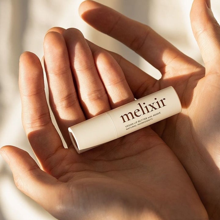 model holding the tube of lip balm