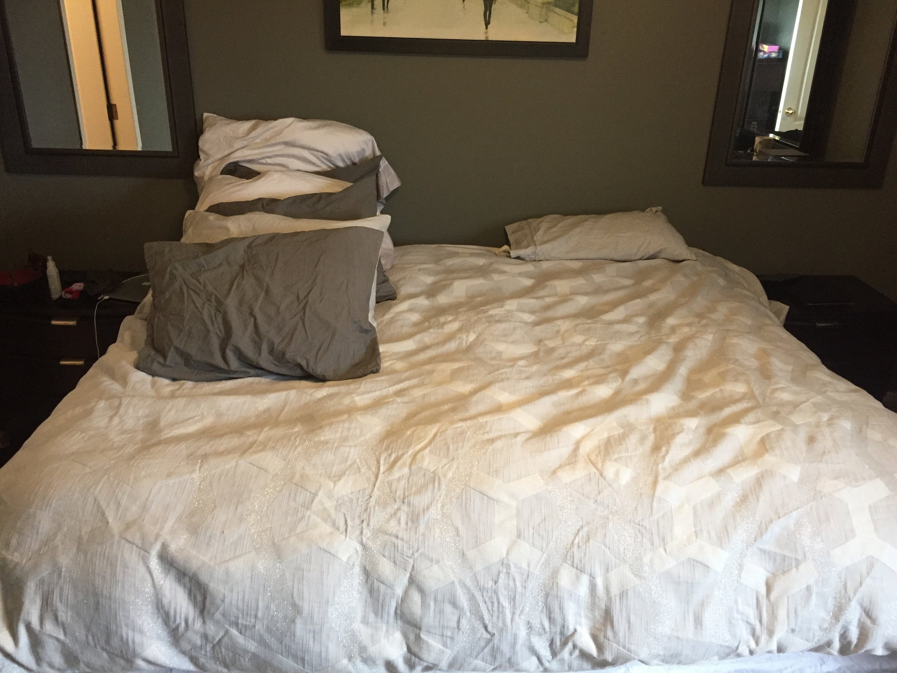 Large bed with many pillows on one side and only one on the other