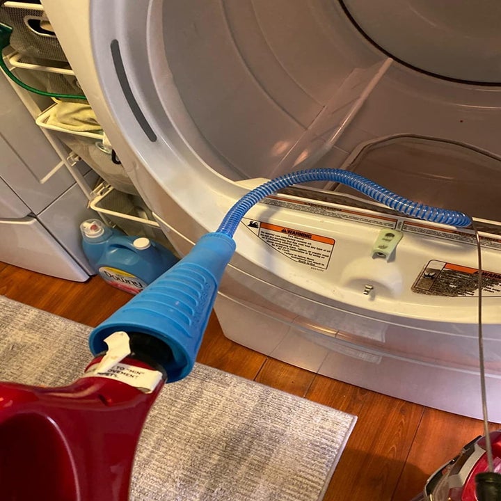 A reviewer photo of the attachment hooked up to a vacuum and fed into the dryer vent 